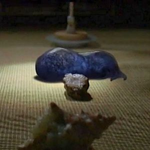 A screenshot of the film The Last Mimzy, showing several of the mysterious toys from the story. The focus of the scene is a blobby, blue, tentacled toy known as the gelatinous mass.