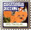 An orange dog with an orange hexagon above their head looks at the camera against a background of a tree. The text reads 'Hydrargyry Kennelz' at the top and 'Spectacular...!' at the bottom. The stamp is brown, with blue and green text.